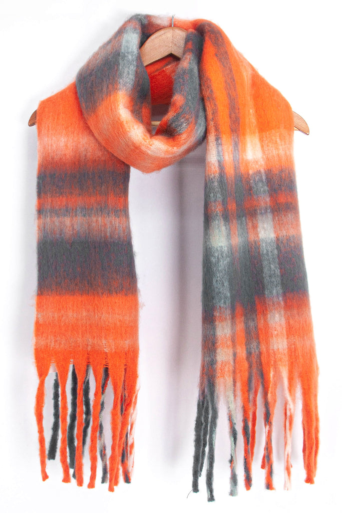 orange and grey tartan scarf draped around a coat hanger, showing how it would look when worn