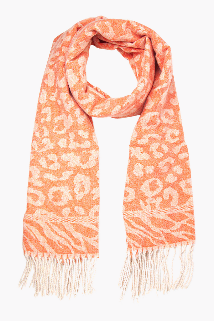 orange blanket scarf with an all over leopard print pattern, with a contrasting zebra print edge and a cream tasselled fringe