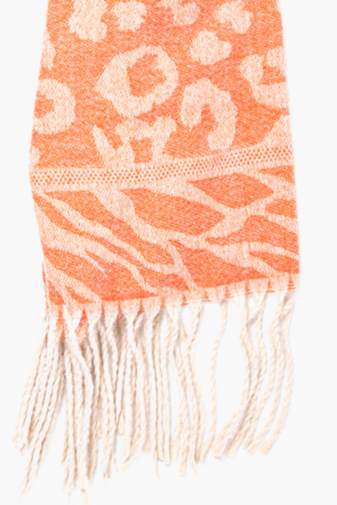 close up of the fringed edge, showing the zebra and leopard print patten on the orange scarf