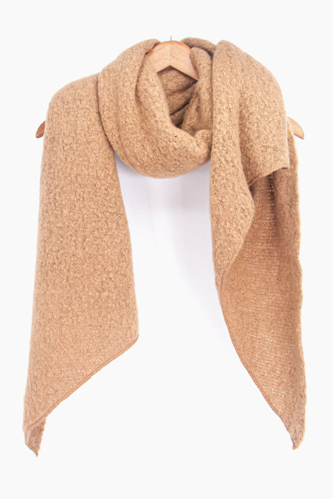 asymmetric camel beige scarf draped around a coat hanger