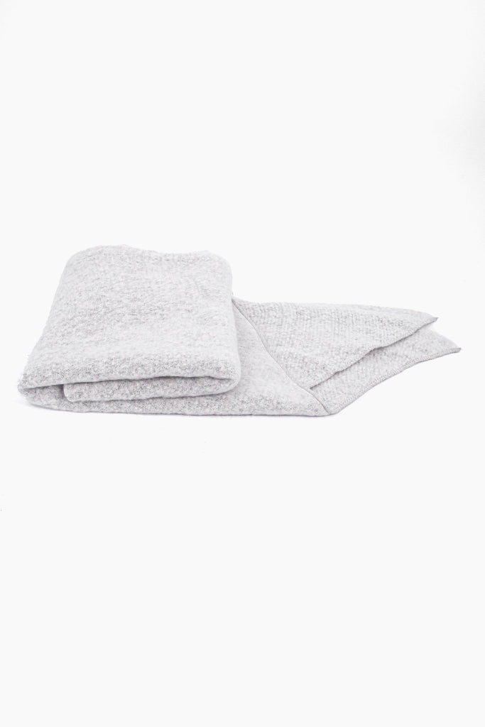 close up of the scarf folded on a flat surface, showing the soft textured fabric