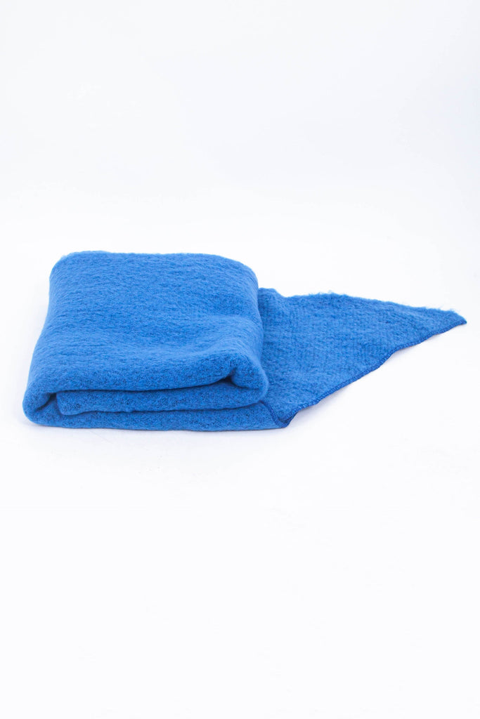 close up of the scarf folded on a flat surface, showing the soft textured fabric