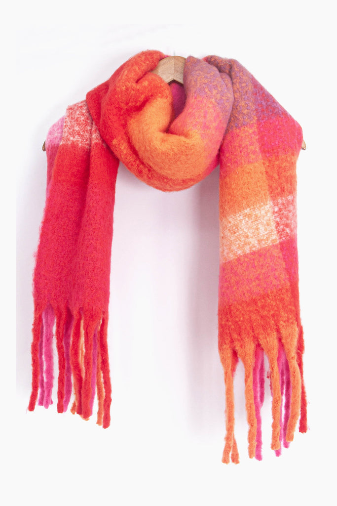 showing the multicoloured square colour block winter scarf draped around a coat hanger, showing how it would look when worn.