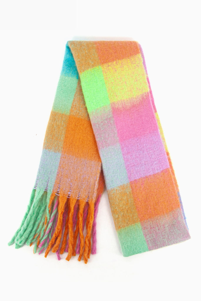 showing the scarf folded while laying flat, the multi colour  square block pattern is highlighted. there are yellow, orange, green, pink and blue tones visible in the design.