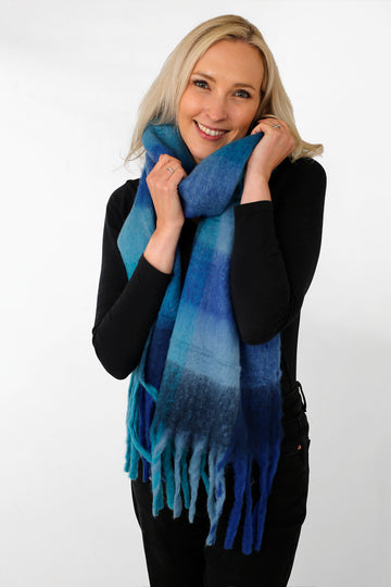 model wearing a blue check print winter scarf with tassles