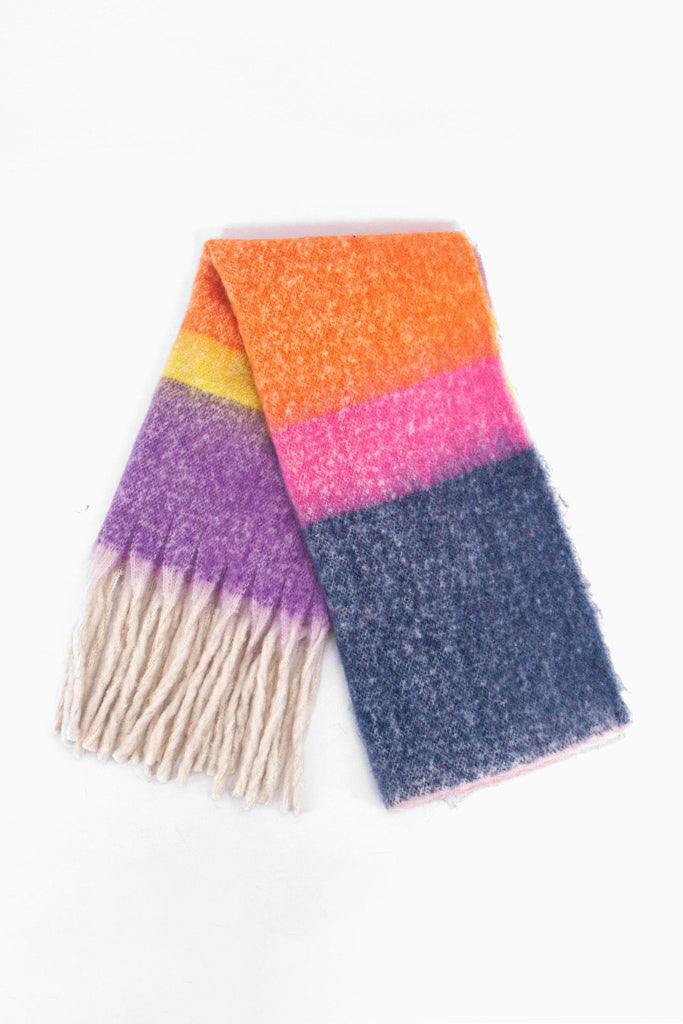 showing the scarf folded while laying flat, the multi colour colour block stripe pattern is highlighted. there are pink, orange, blue, purple and yellow tones visible in the design.