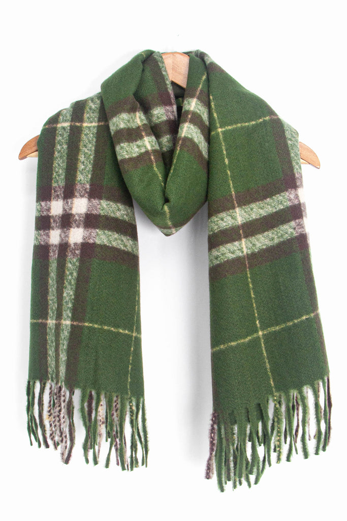 showing the green and brown plaid pattern winter scarf draped around a coat hanger, showing how it would look when worn.