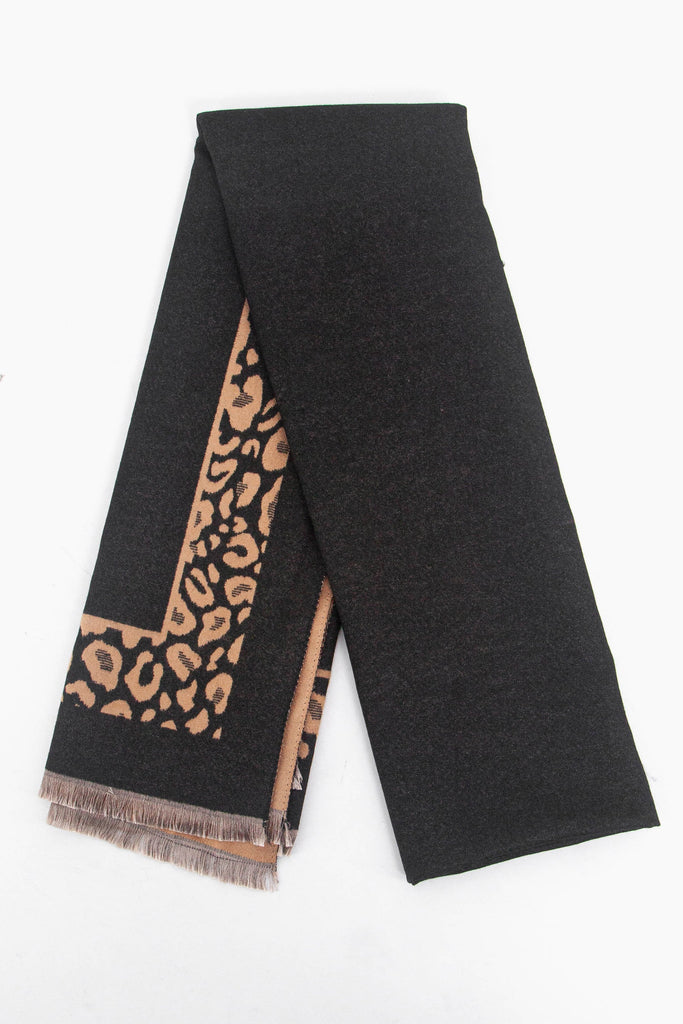 showing the scarf folded flat, the leopard print border is clearly visible and contrasts the plain black background