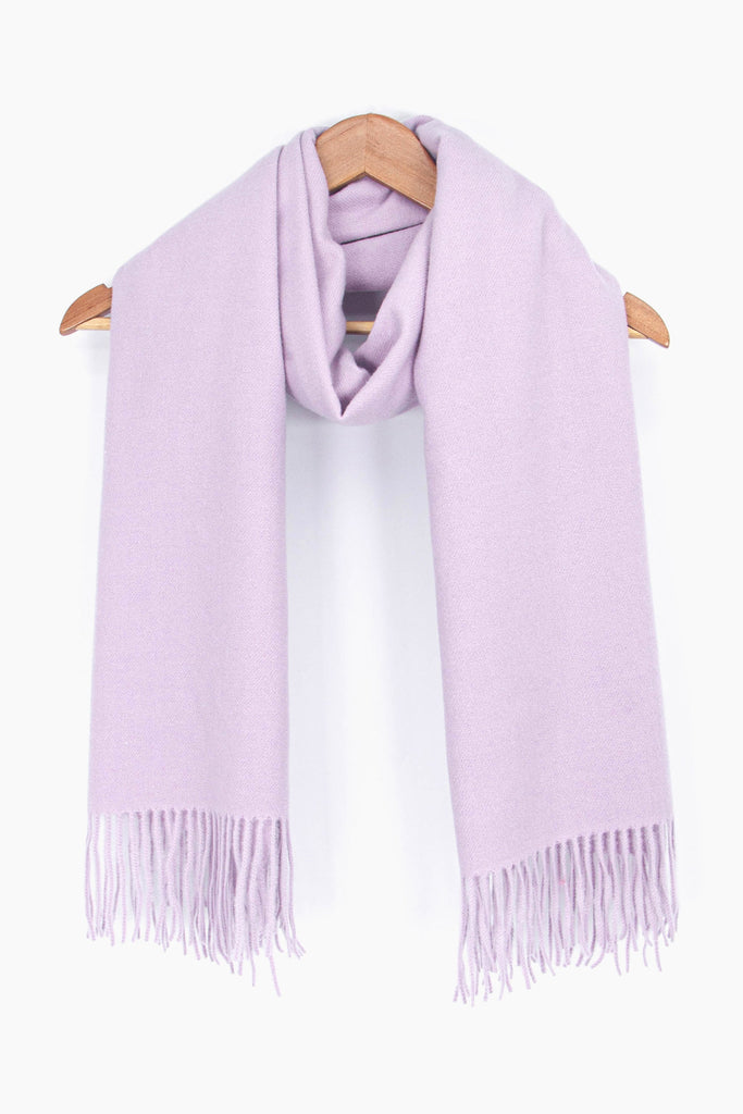showing the plain lilac winter scarf draped around a coat hanger, showing how it would look when worn