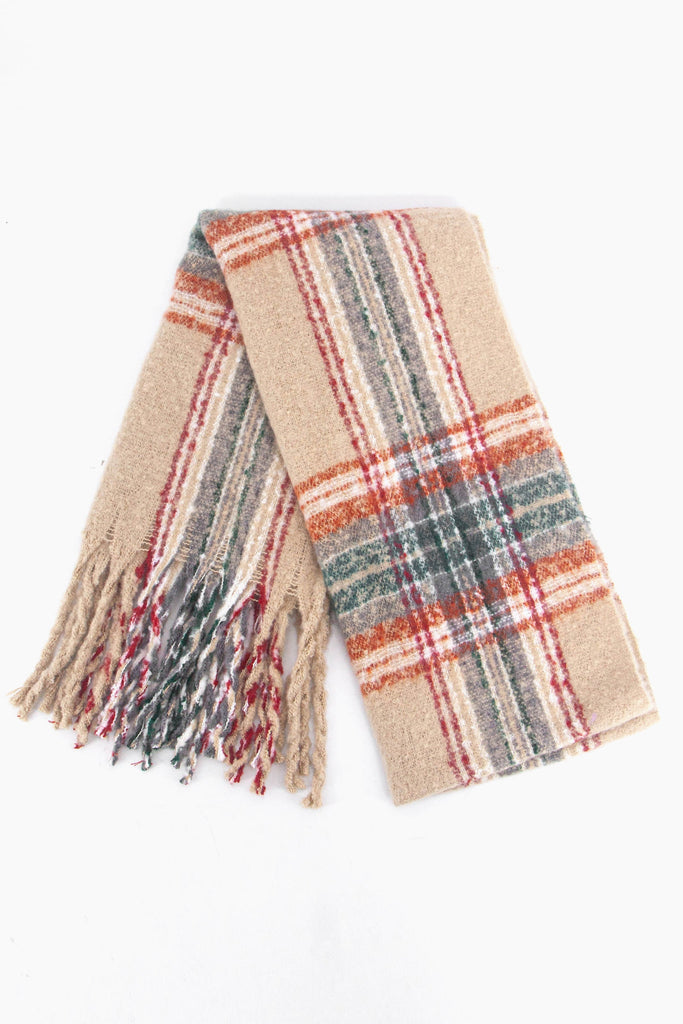 showing the scarf folded while laying flat, the cream tartan checked pattern is clear as is the colourful tassel trim.