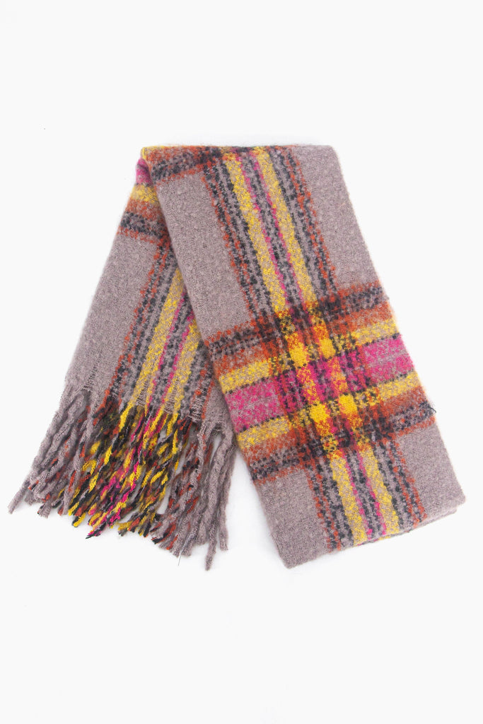 showing the scarf folded while laying flat, the grey tartan checked pattern is clear as is the colourful tassel trim.