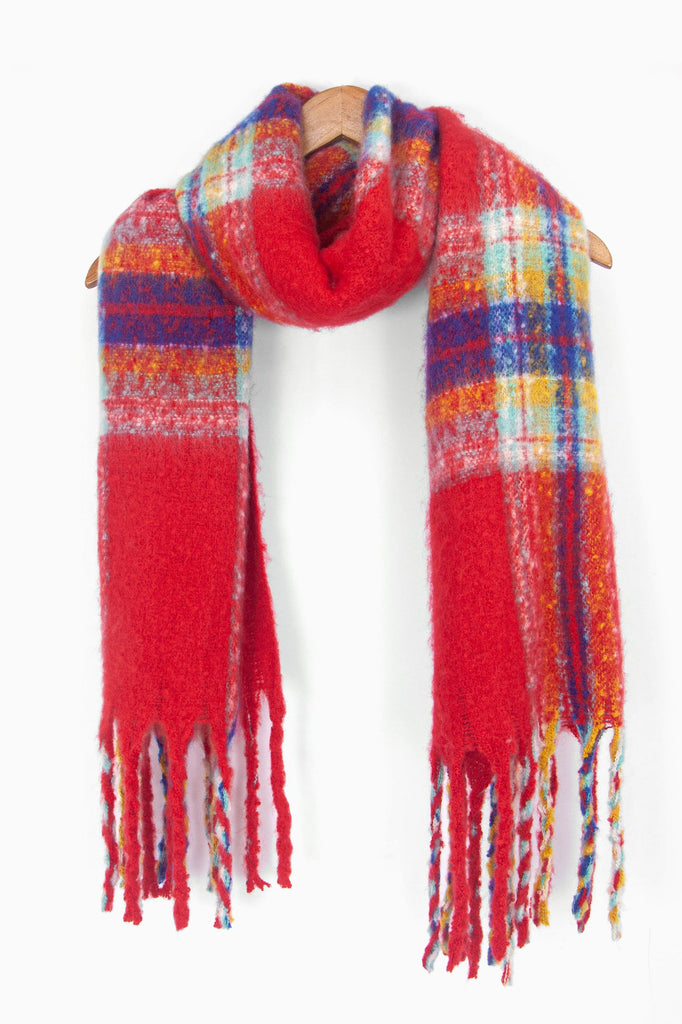 showing the red traditional checked pattern winter scarf draped around a coat hanger, showing how it would look when worn.