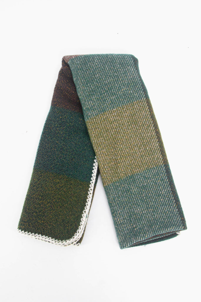 showing the scarf folded while laying flat, the square check block pattern is highlighted and shows the green and brown colourways.