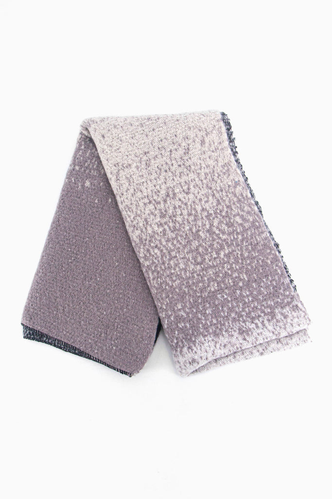 showing the scarf folded while laying flat, the grey ombre pattern is highlighted.