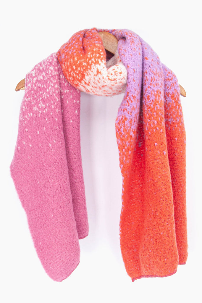 showing the fuchsia pink ombre winter scarf draped around a coat hanger, showing how it would look when worn.