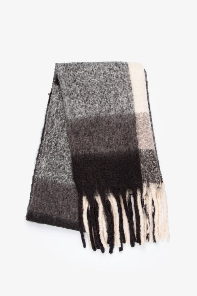 showing the scarf folded, the black square colour block pattern is highlighted and the tassel trim is prominent.