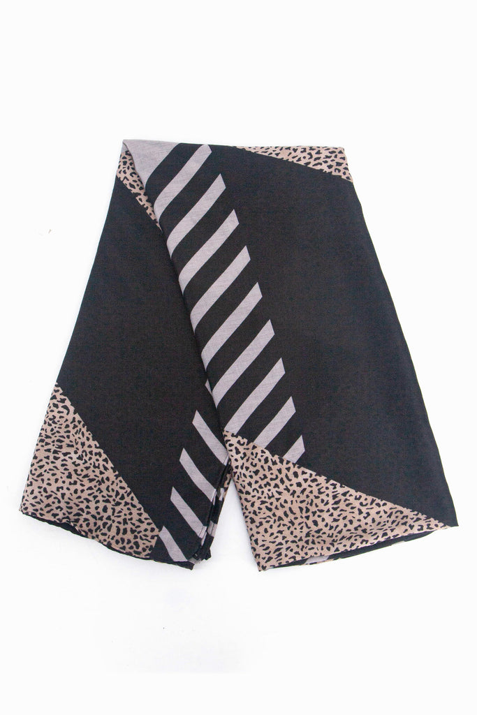 showing the scarf folded, showing the black background, animal stripes and neutral animal print blocks on the design