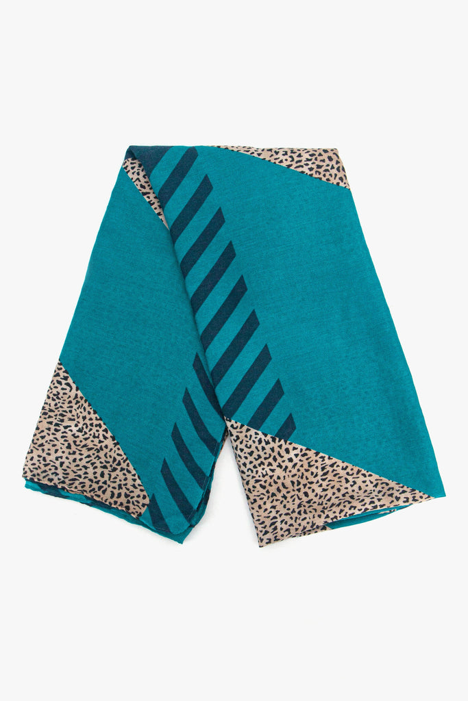 showing the scarf folded, showing the blue background, animal stripes and neutral animal print blocks on the design