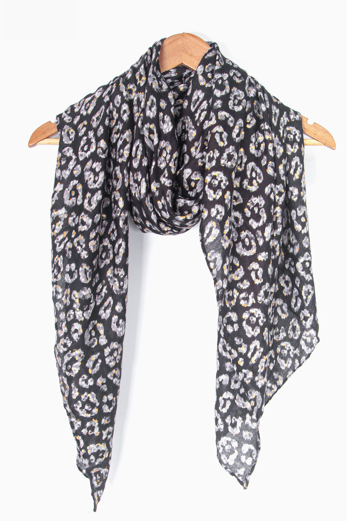 showing the scarf draped around a coat hanger, showing the all over pattern and how it would look when worn