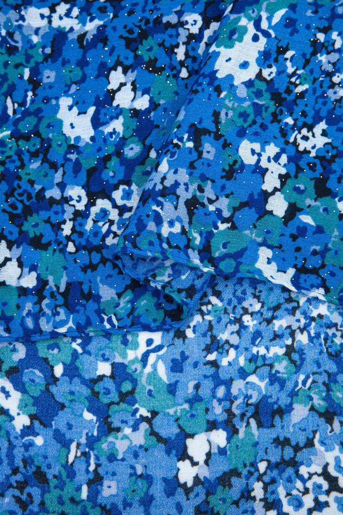 close up of the soft viscose fabric, the blue floral print pattern is are clearly visible