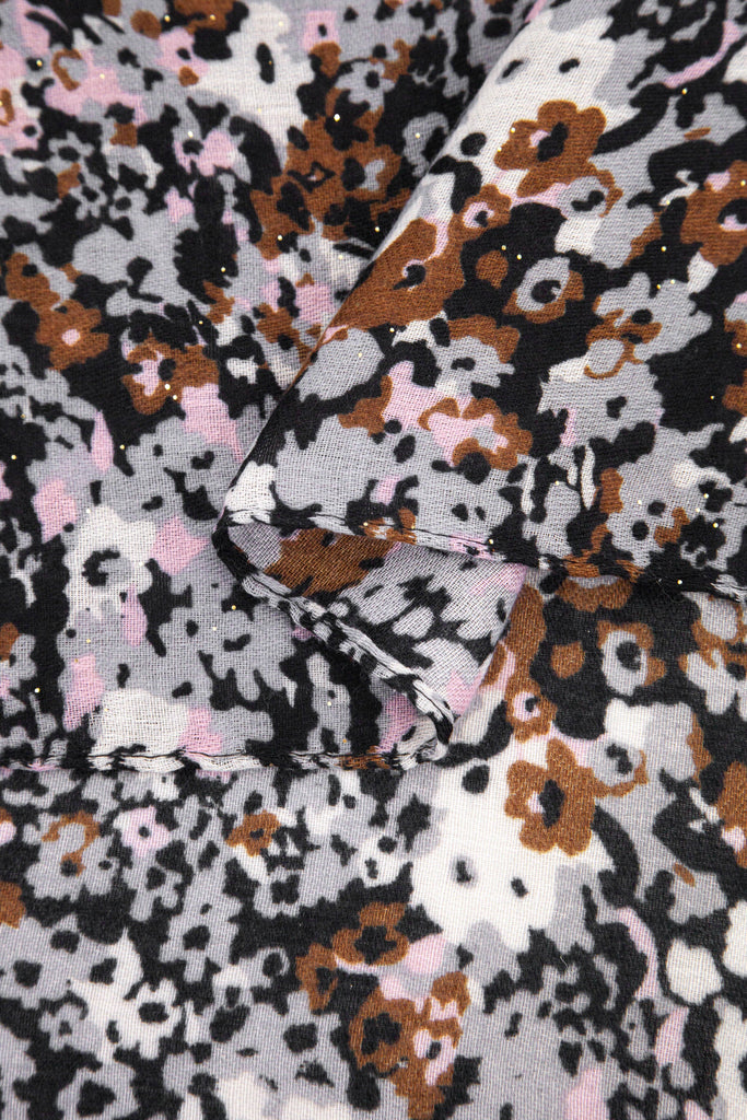 close up of the soft viscose fabric, the neutral floral print pattern is are clearly visible