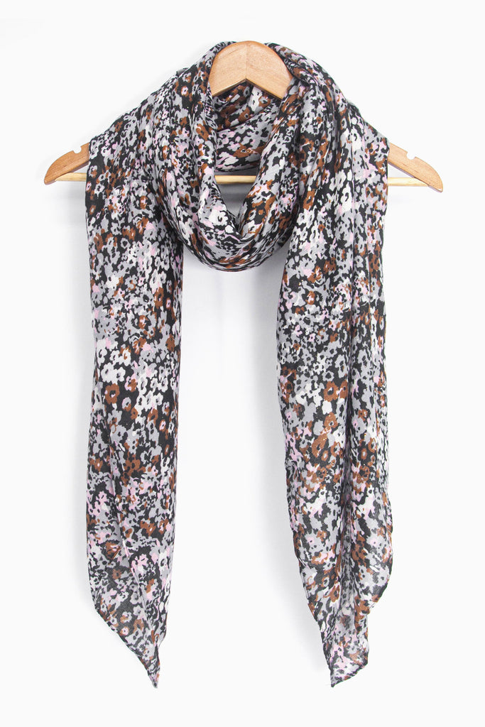 showing the scarf draped around a coat hanger, showing the all over pattern and how it would look when worn