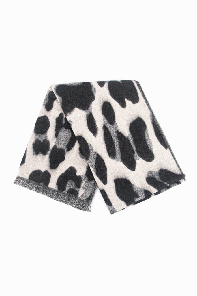 showing the scarf folded while laying flat, the cream animal print pattern and sparkly silver glitter design is shown