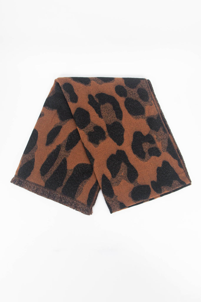 showing the scarf folded while laying flat, the neutral animal print pattern and sparkly silver glitter design is shown