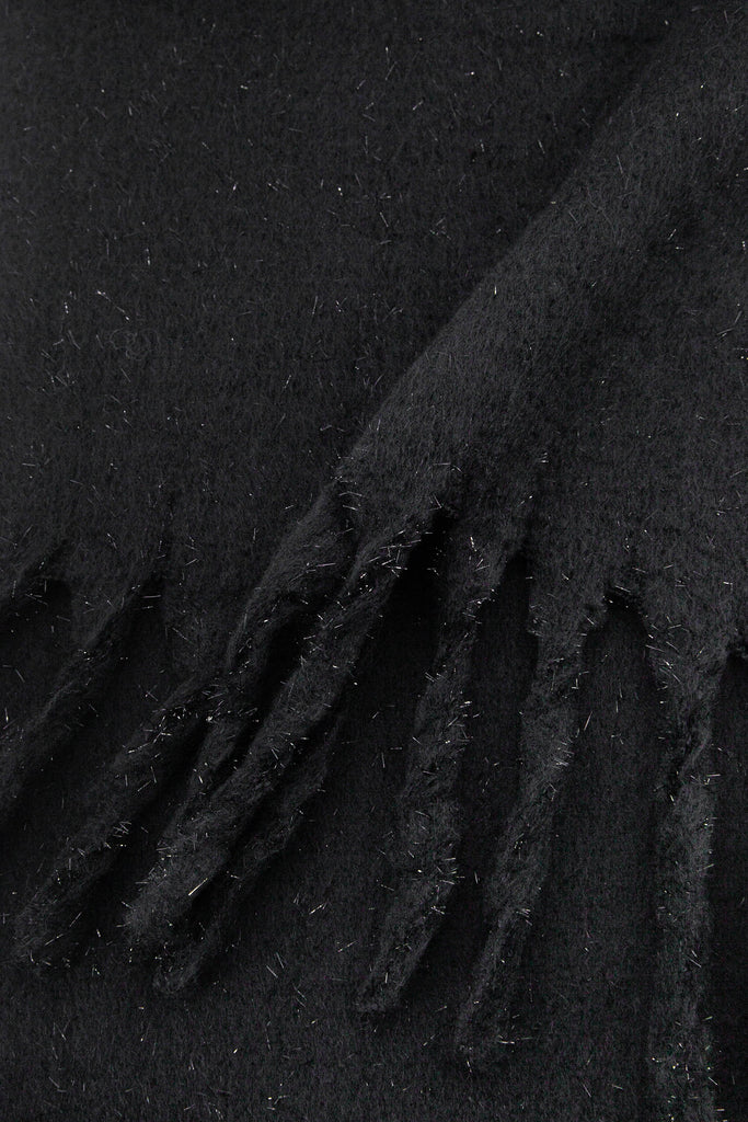 close up of the knitted material of the winter blanket scarf, the silver tinsel fibres are clearly shown