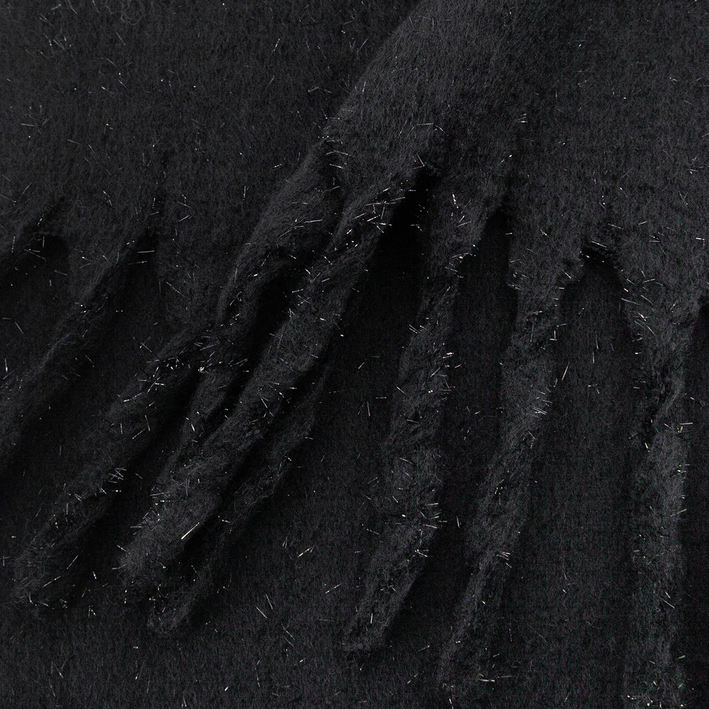 close up of the knitted material of the winter blanket scarf, the silver tinsel fibres are clearly shown