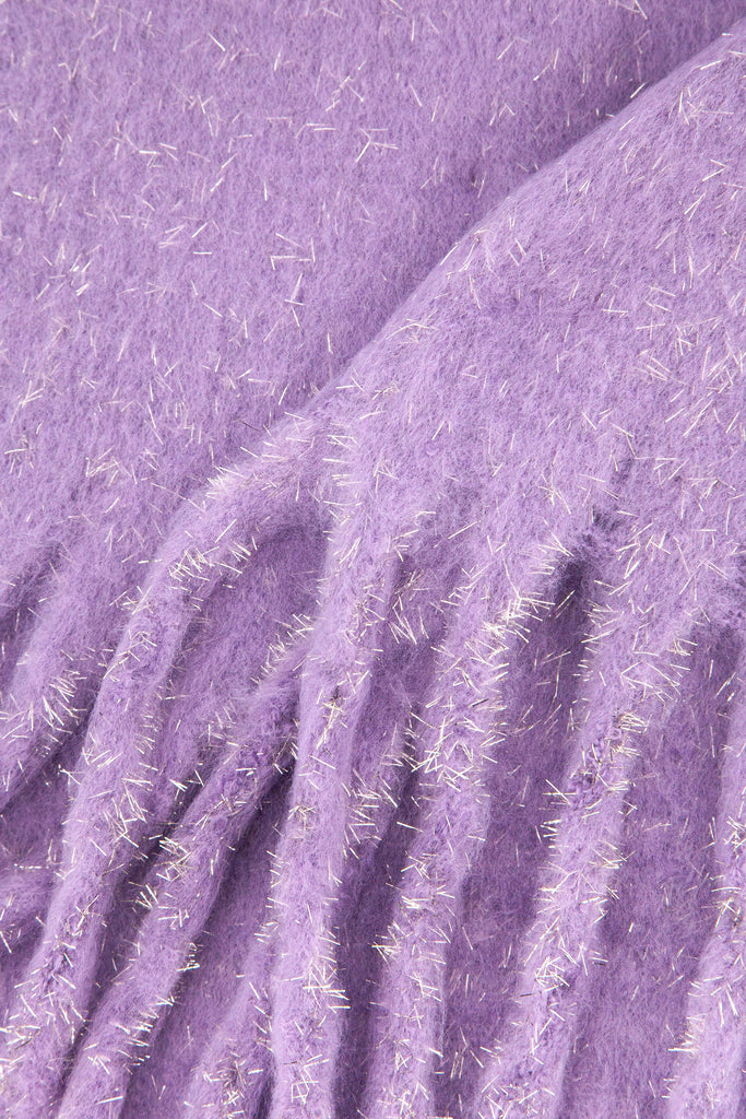 close up of the knitted material of the winter blanket scarf, the silver tinsel fibres are clearly shown