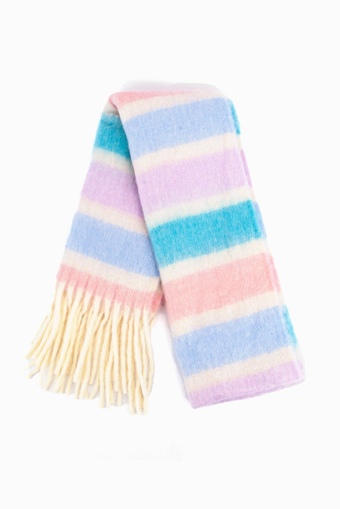 showing the scarf folded while laying flat, the lilac, blue and pink striped pattern is highlighted as is the cream tassel fringe