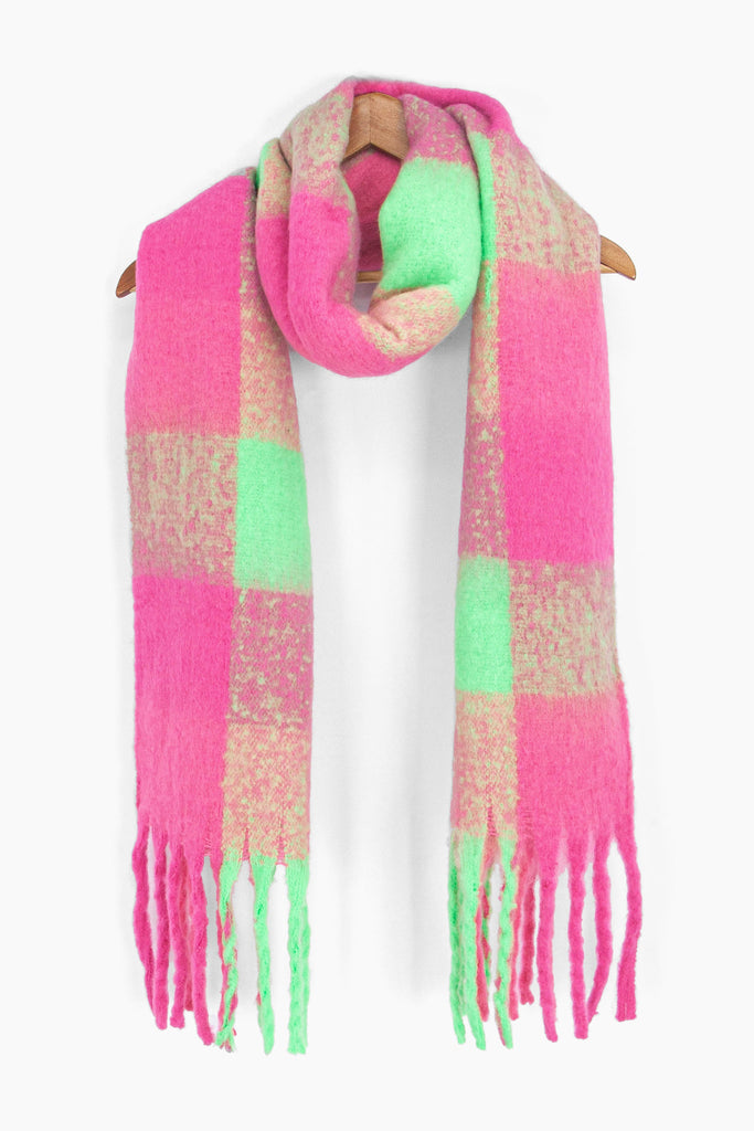 showing the pink, green check colour block winter scarf draped around a coat hanger, showing how it would look when worn.