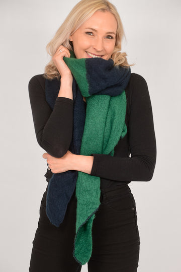 model wearing a winter scarf which is half green and half navy blue