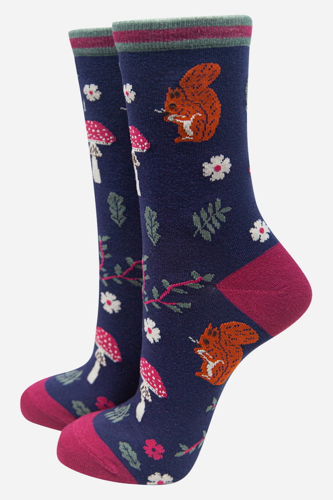 blue socks with pink heel, toe and trim with an all over pattern of red toadstools and red squirrels and leaves
