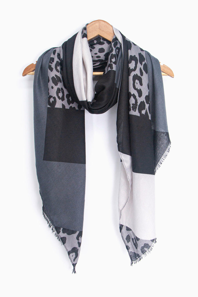 showing the grey and lightweight scarf draped around a coat hanger, showing how it would look when worn.