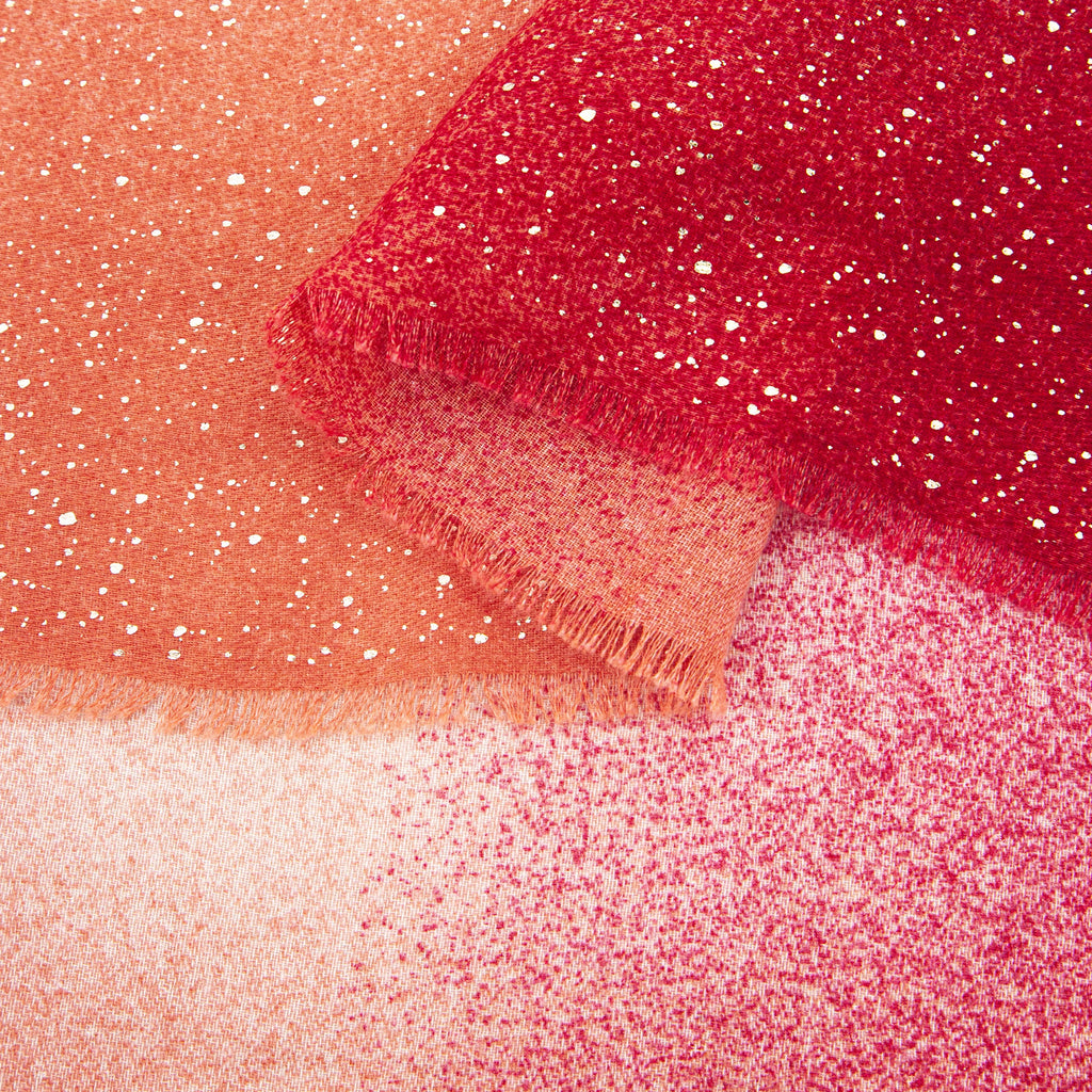 close up of the soft viscose fabric, the red ombre and foil speckles are clearly visible.