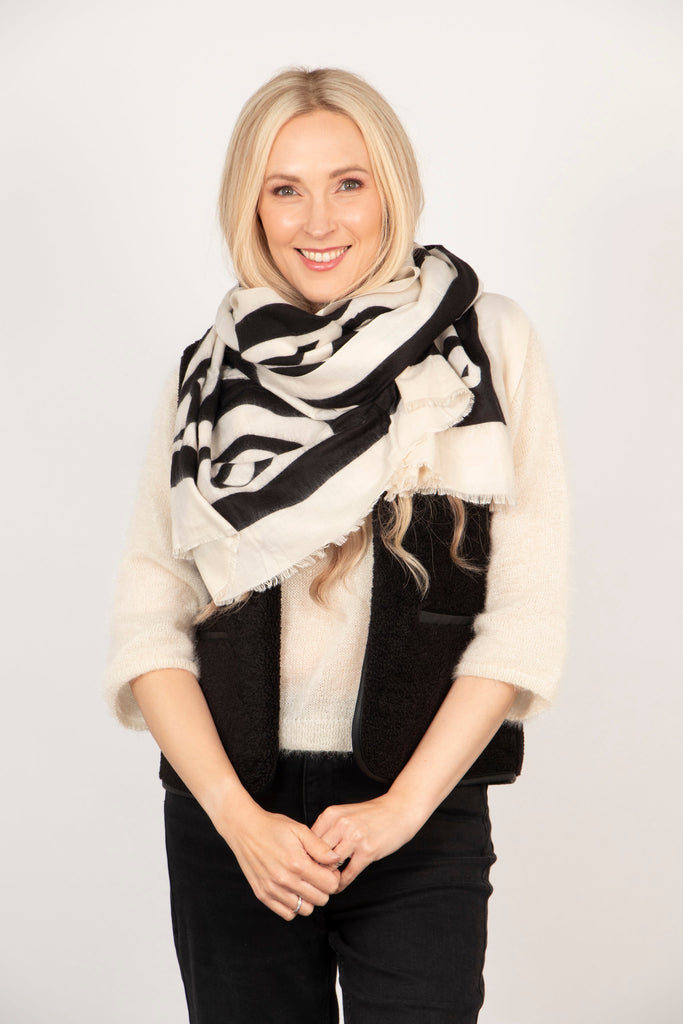 black and cream abstract pattern scarf shown wrapped around the neck loosely