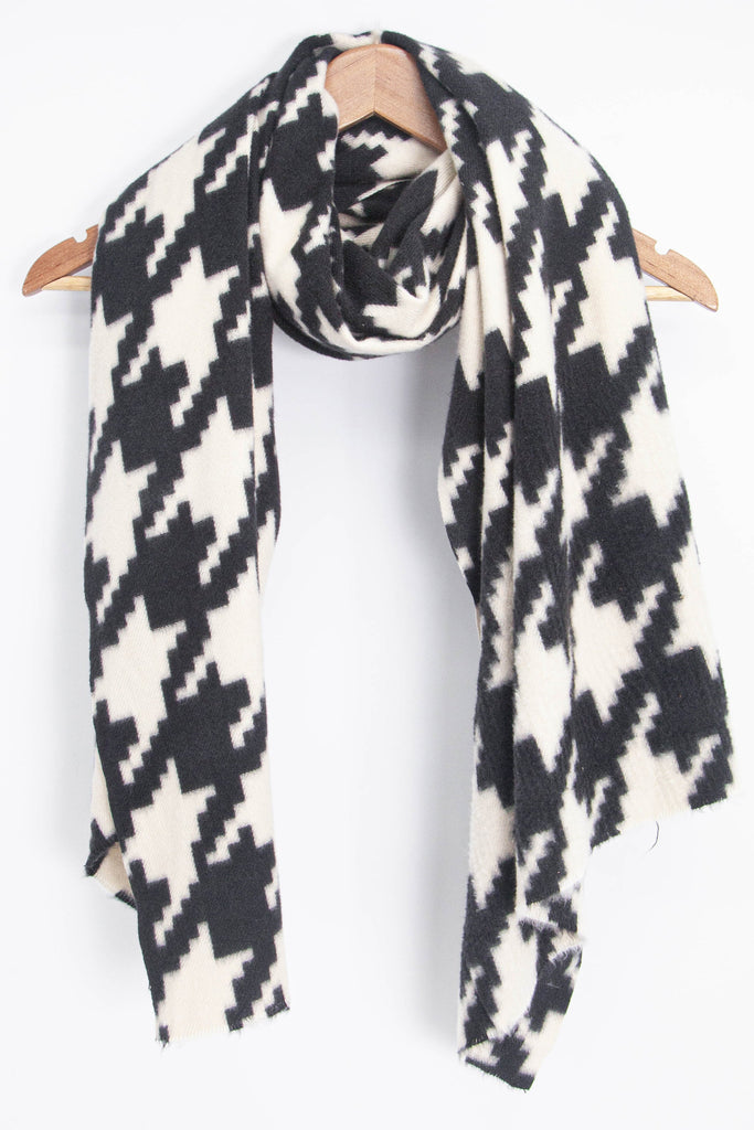 showing the scarf draped around a coat hanger, showing the all over pattern and how it would look when worn