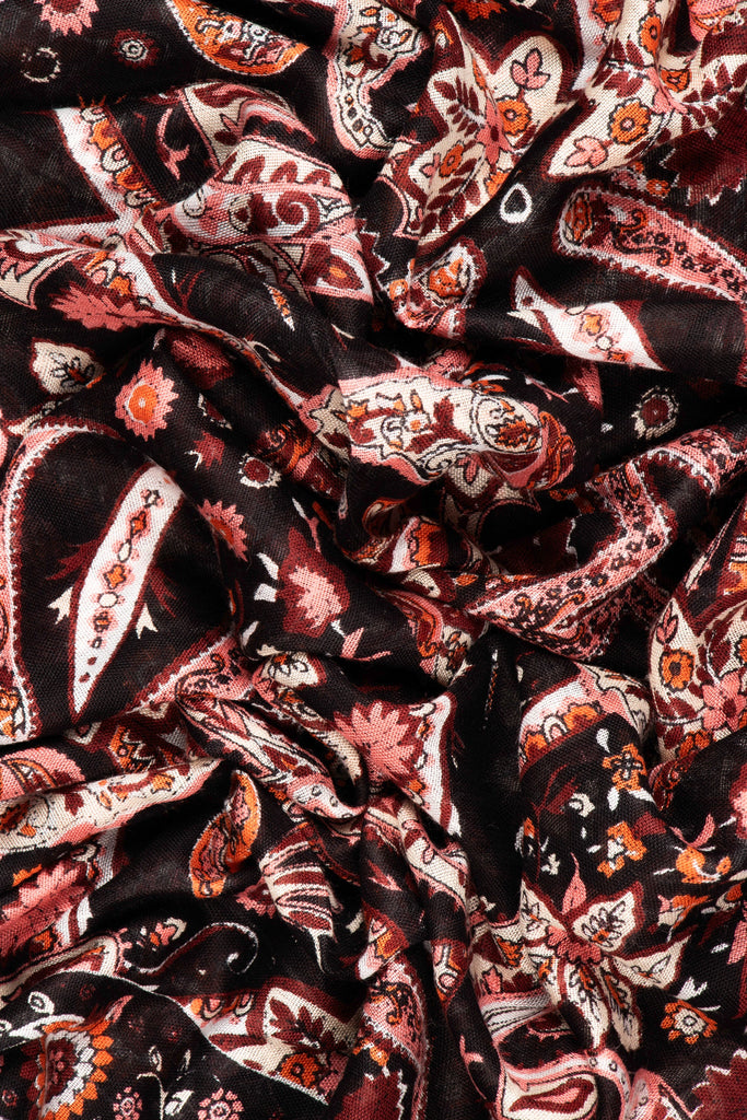 showing the scarf folded, the black and orange mosaic pattern is shown, the scarf also has a plain border around the outer edge which is black the same as the base of the design