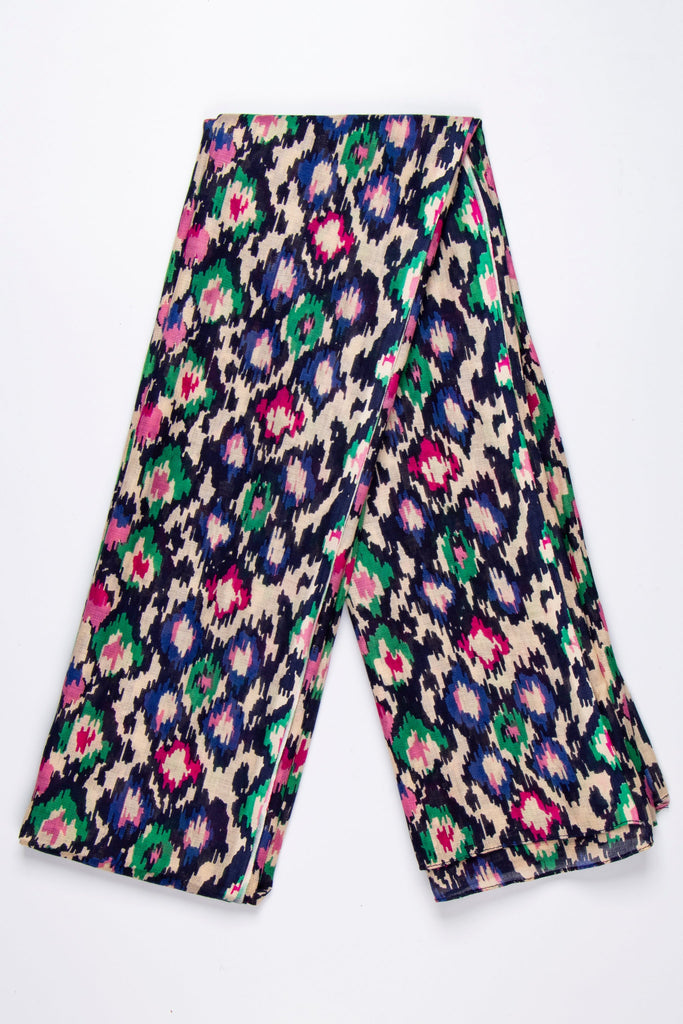 showing the scarf folded, the abstract spot pattern is shown all over the design. the base of the scarf is beige and black with green, pink and blue spots and pattern all over