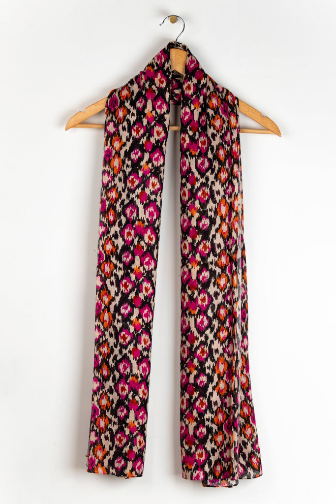 showing the scarf draped around a coat hanger, showing the all over pattern and how it would look when worn