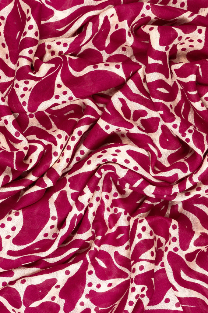 close up of the soft viscose fabric, the fuchsia and cream colourways are clearly visible