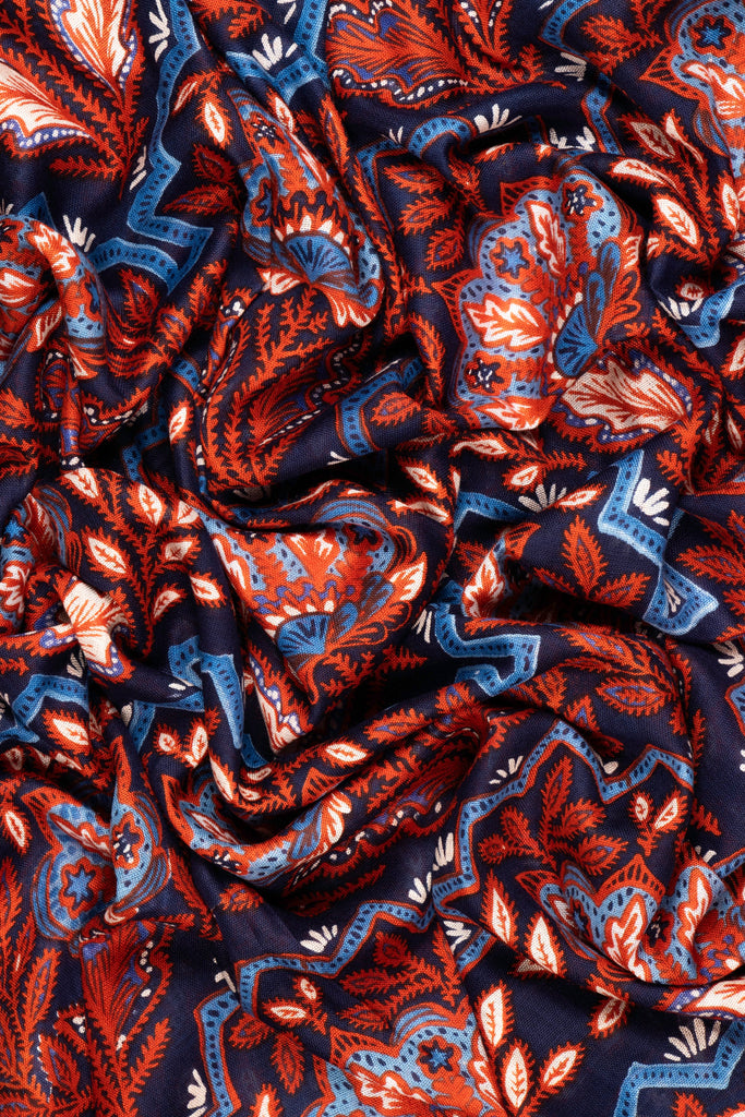 showing the scarf folded, the blue and coral floral mosaic pattern is clearly shown and covers the entire scarf.