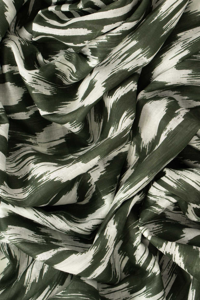 close up image of the lightweight cotton fabric and dark khaki green aztec pattern