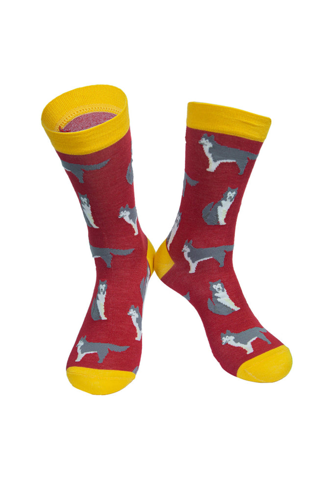 red socks with a yellow heel, toe and cuff with an all over pattern of husky dogs