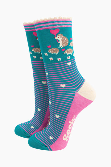 teal bamboo socks with pink horizontal pinstripes. on the ankle of the socks there is an adult hedgehog with three baby hedgehogs each carrying pink love heart shaped balloons.