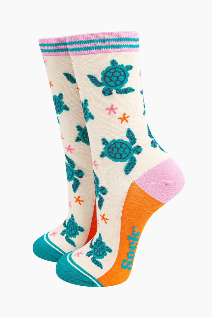 womens-bamboo-socks-cream-sea-turtles-and-starfish-pattern-shows-turquoise-swimming-turtles-and-small-pink-and-orange-starfish