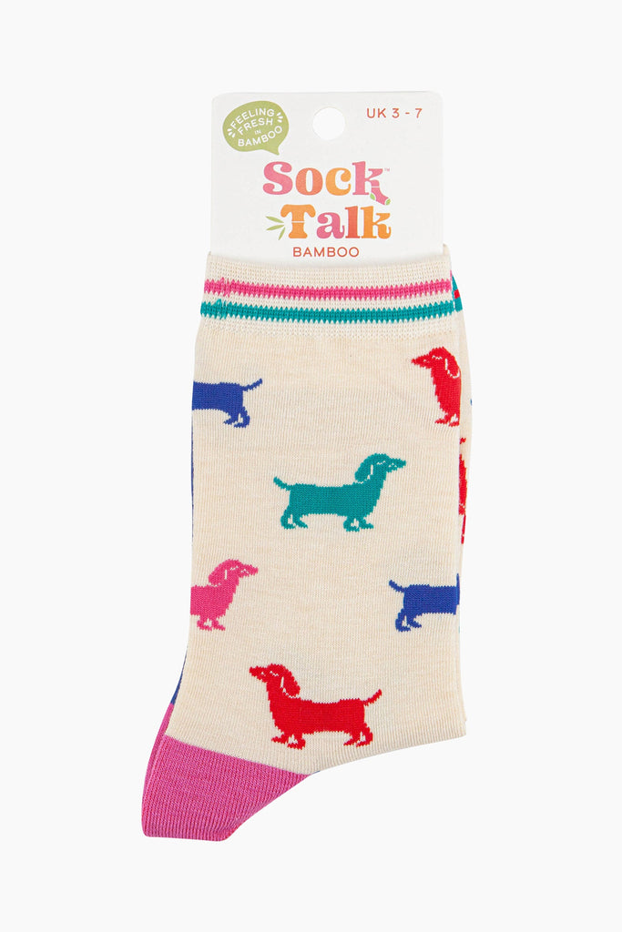 women's cream and multicoloured sausage dog ankle socks in their sock talk packaging, the socks are a uk size 3-7.