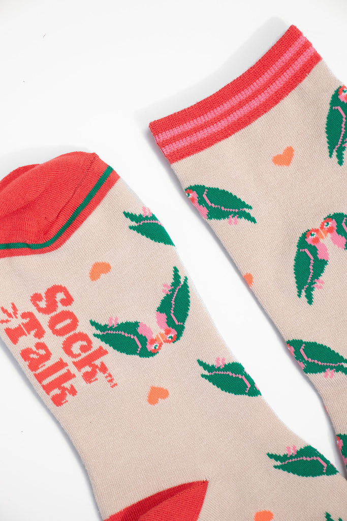 close up of the toe and cuff, the toe is a coral pink with a green border stripe, the cuff is pink and coral striped